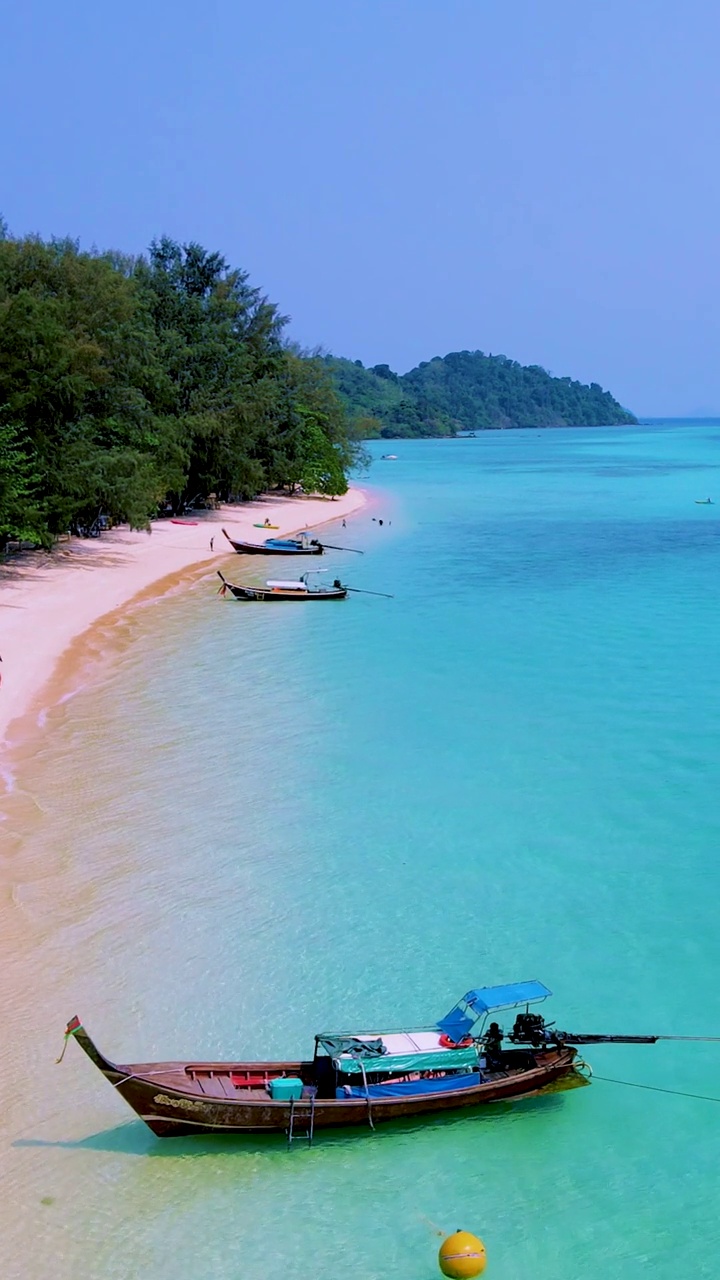 泰国南部的Koh Kradan岛，海滩上有长尾船和蓝绿色的海洋视频素材