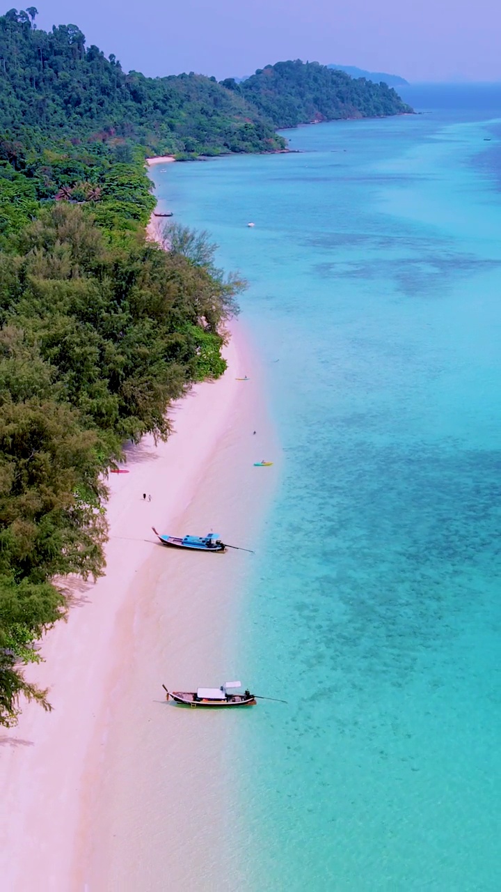 泰国南部的Koh Kradan岛，海滩上有长尾船和蓝绿色的海洋视频素材