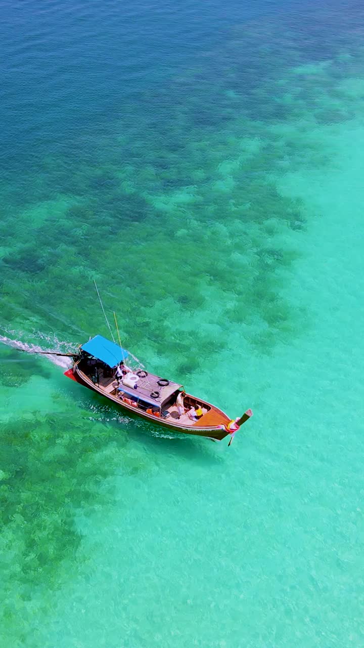 泰国南部的Koh Kradan岛，海滩上有长尾船和蓝绿色的海洋视频素材