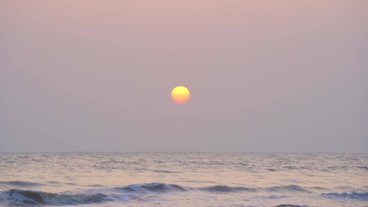 从海滩上看日出，美丽的金色天空和小海浪打在海滩上。视频素材