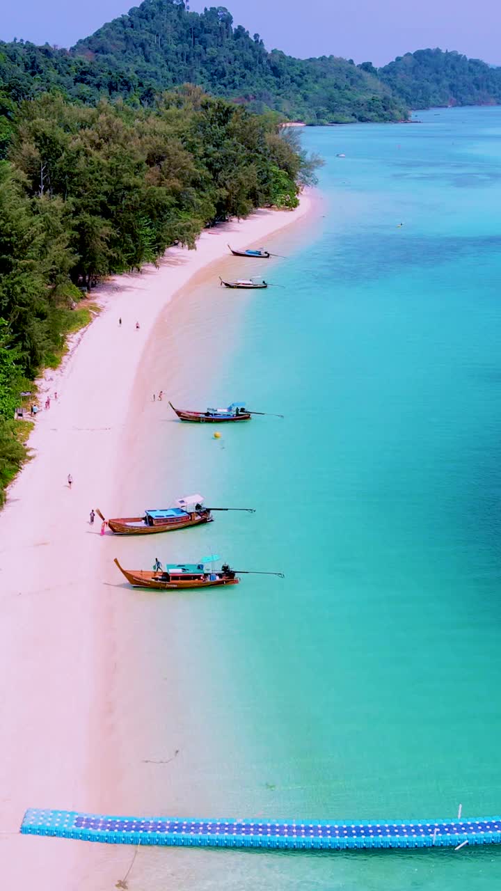 泰国南部的Koh Kradan岛，海滩上有长尾船和蓝绿色的海洋视频素材