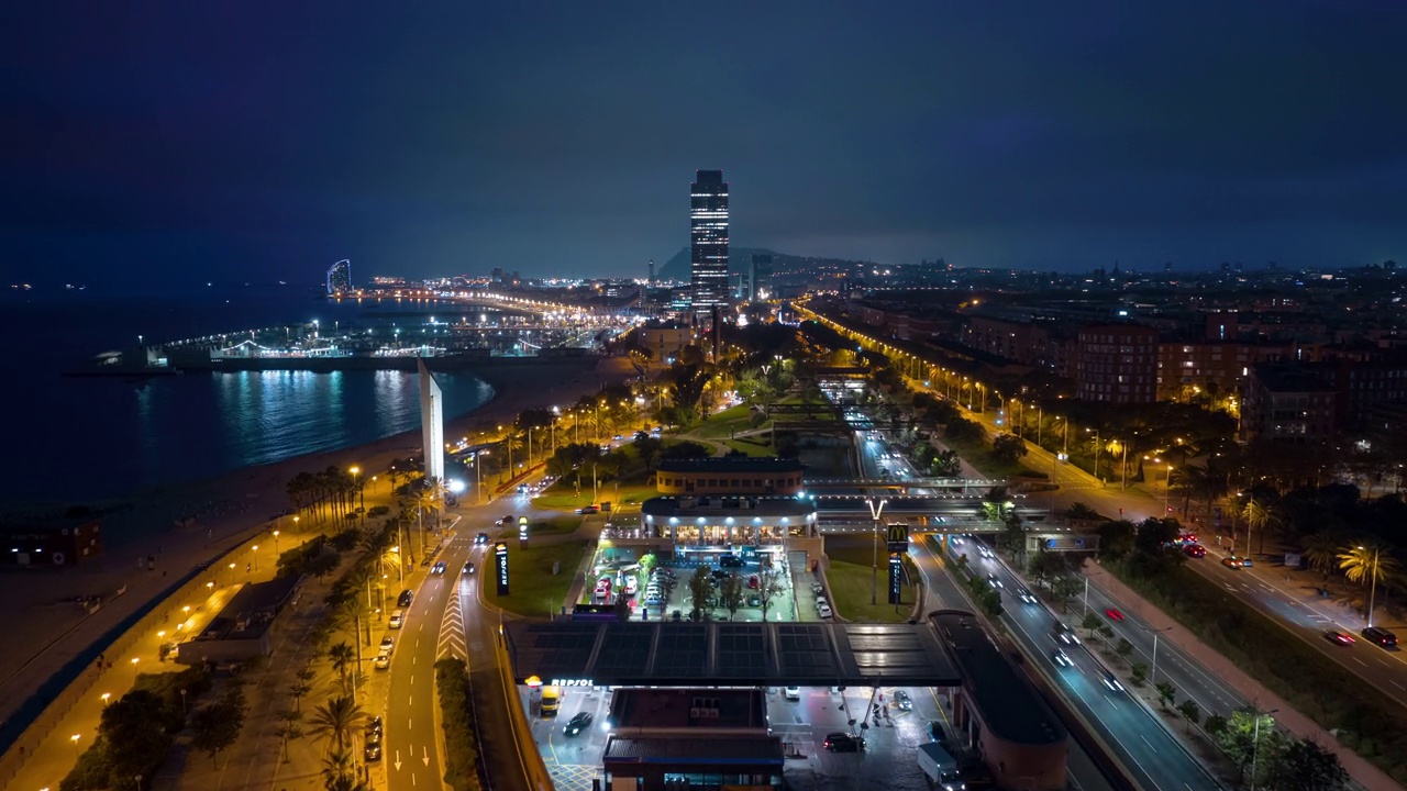 夜间照明飞行在巴塞罗那市著名的拥挤的海滩交通湾航拍全景4k延时西班牙视频素材