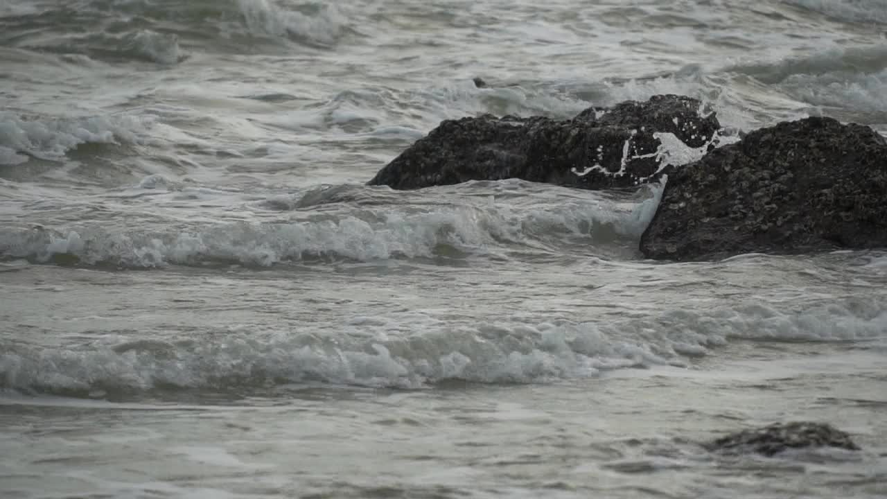 海浪拍打着海滩上的石头。视频素材