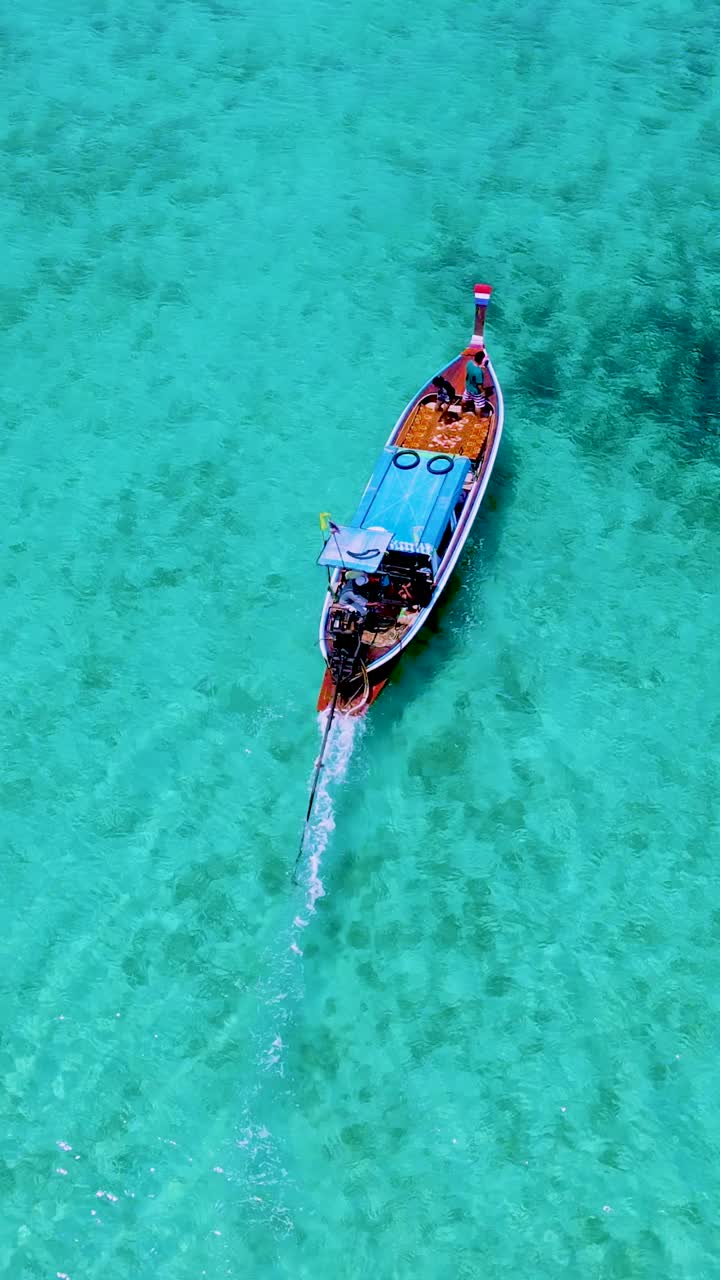 泰国南部的Koh Kradan岛，海滩上有长尾船和蓝绿色的海洋视频素材