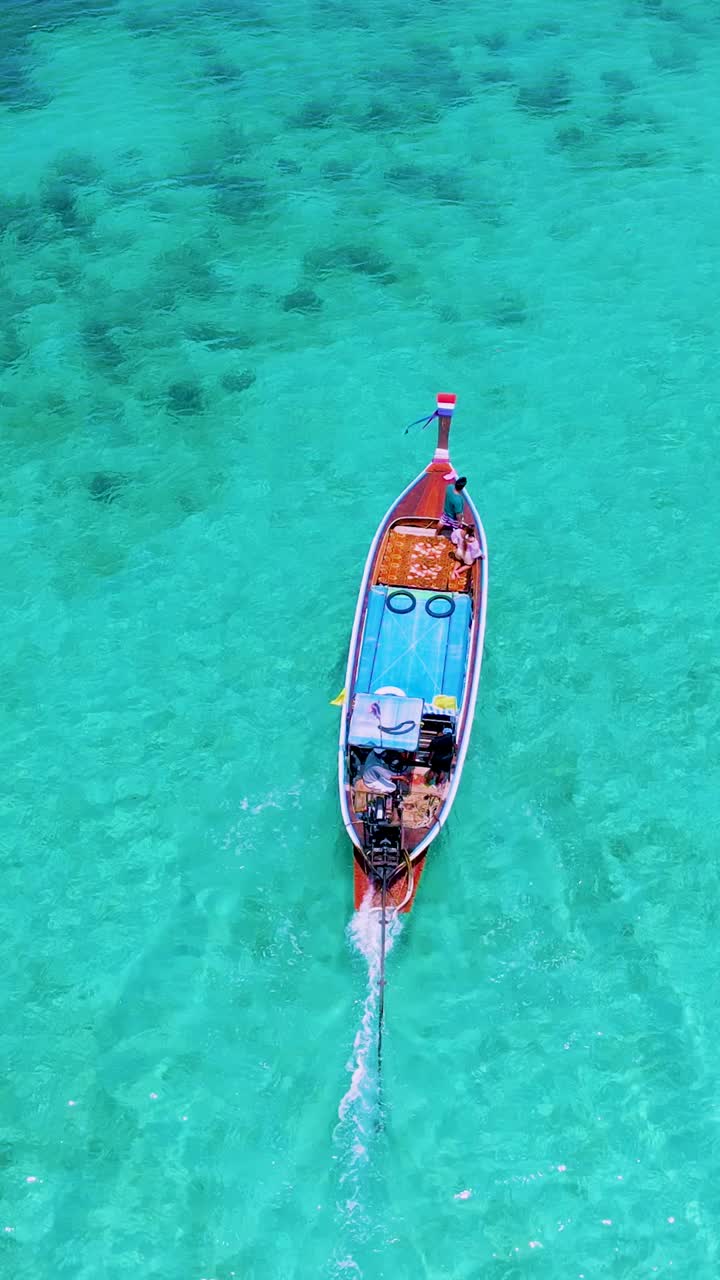 泰国南部的Koh Kradan岛，海滩上有长尾船和蓝绿色的海洋视频素材