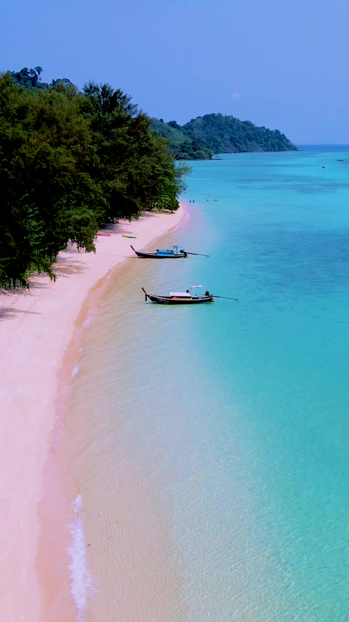 泰国南部的Koh Kradan岛，海滩上有长尾船和蓝绿色的海洋视频素材