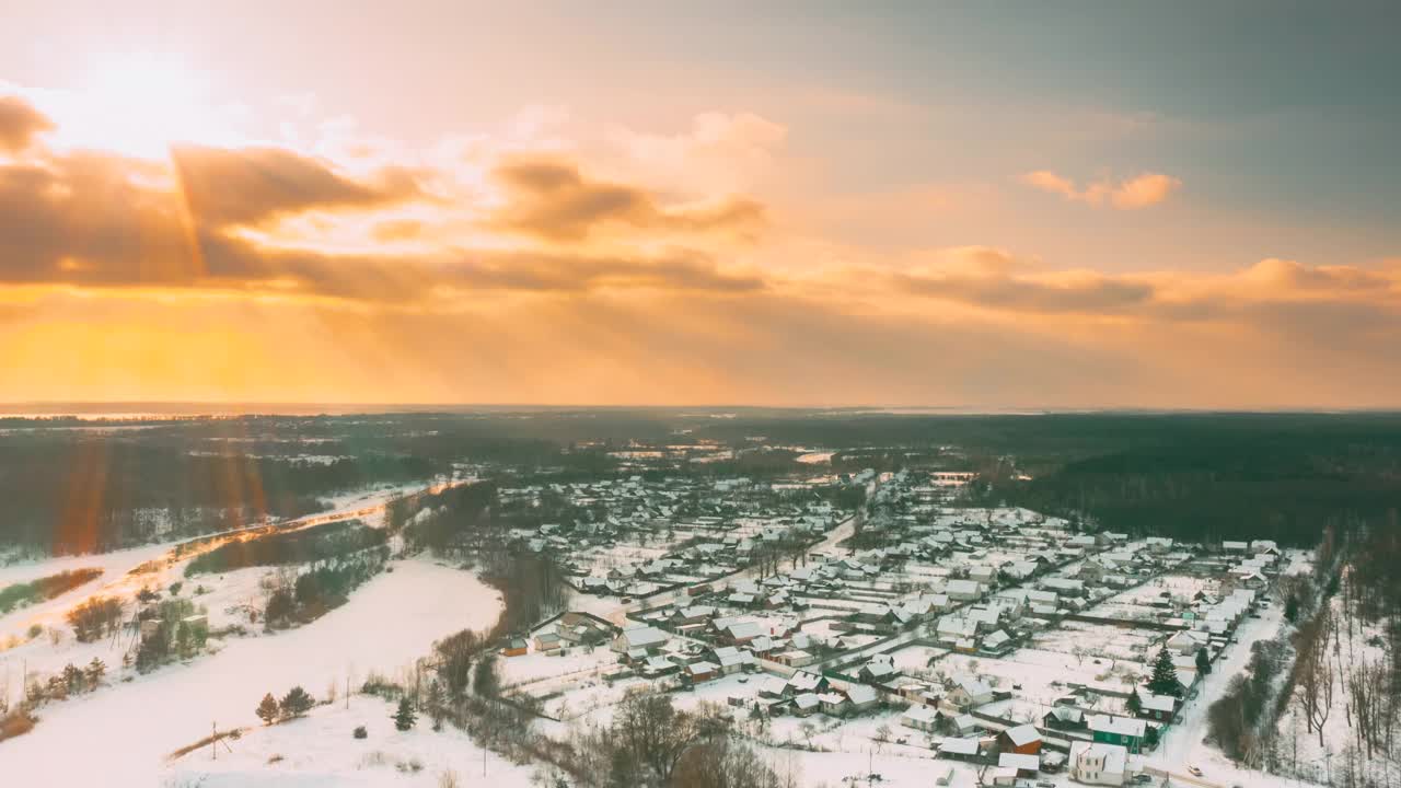 太阳照耀在城市地平线上在冬季日落。Timelapse Dronelapse Hyperlapse。鸟瞰图的城镇，村庄，城市景观天际线交通在雪景。住宅鸟瞰图。时间流逝视频素材