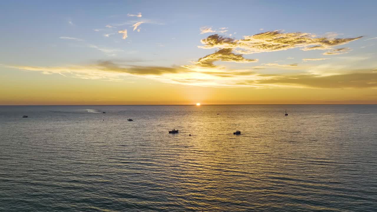 日落时白色游艇的鸟瞰图，漂浮在波纹表面的海浪上。水上摩托艇娱乐视频素材