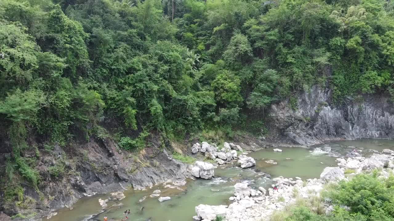 沿着茂密的森林，有石头和岩石的小溪上的无人机镜头视频素材