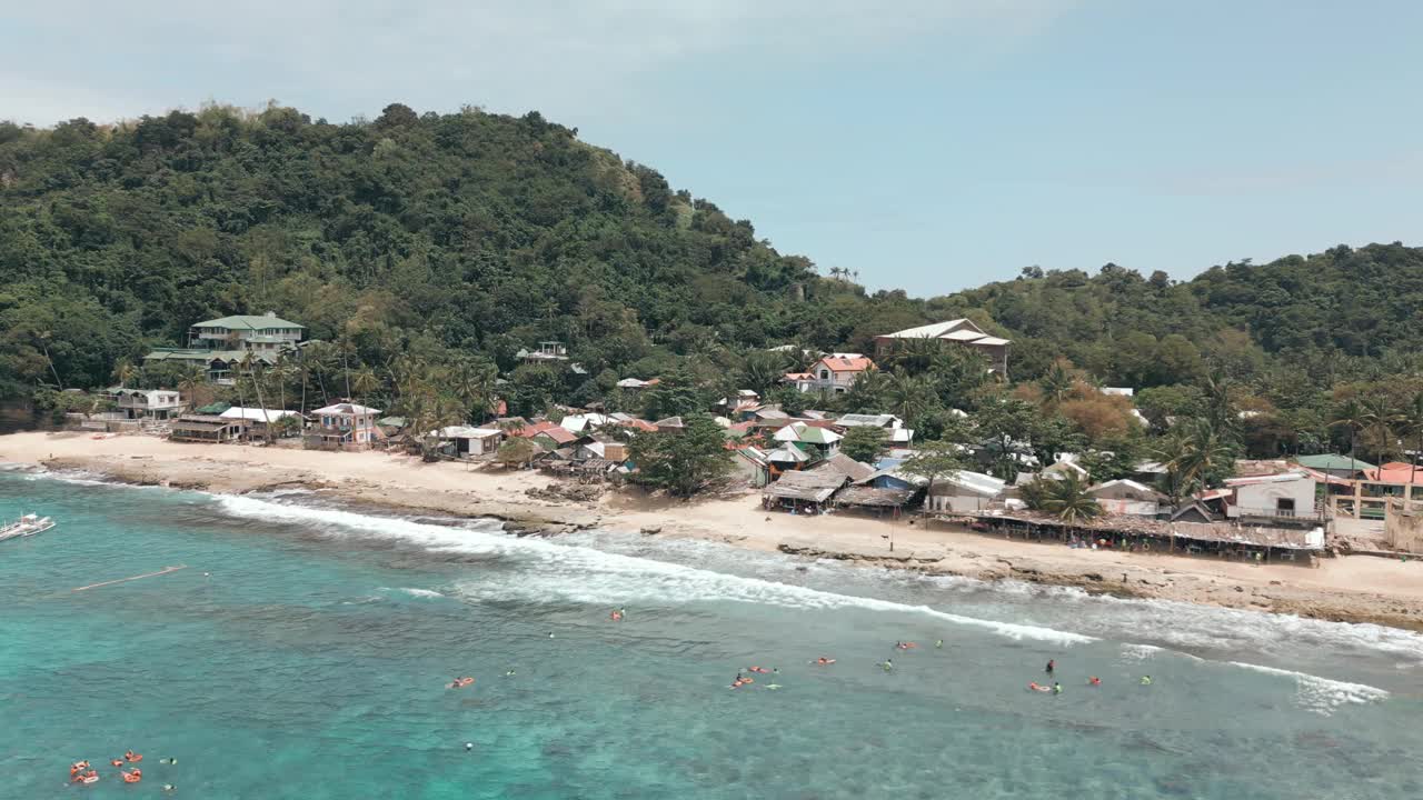 在阳光明媚的日子里，无人机拍摄的海滩和森林山丘视频素材