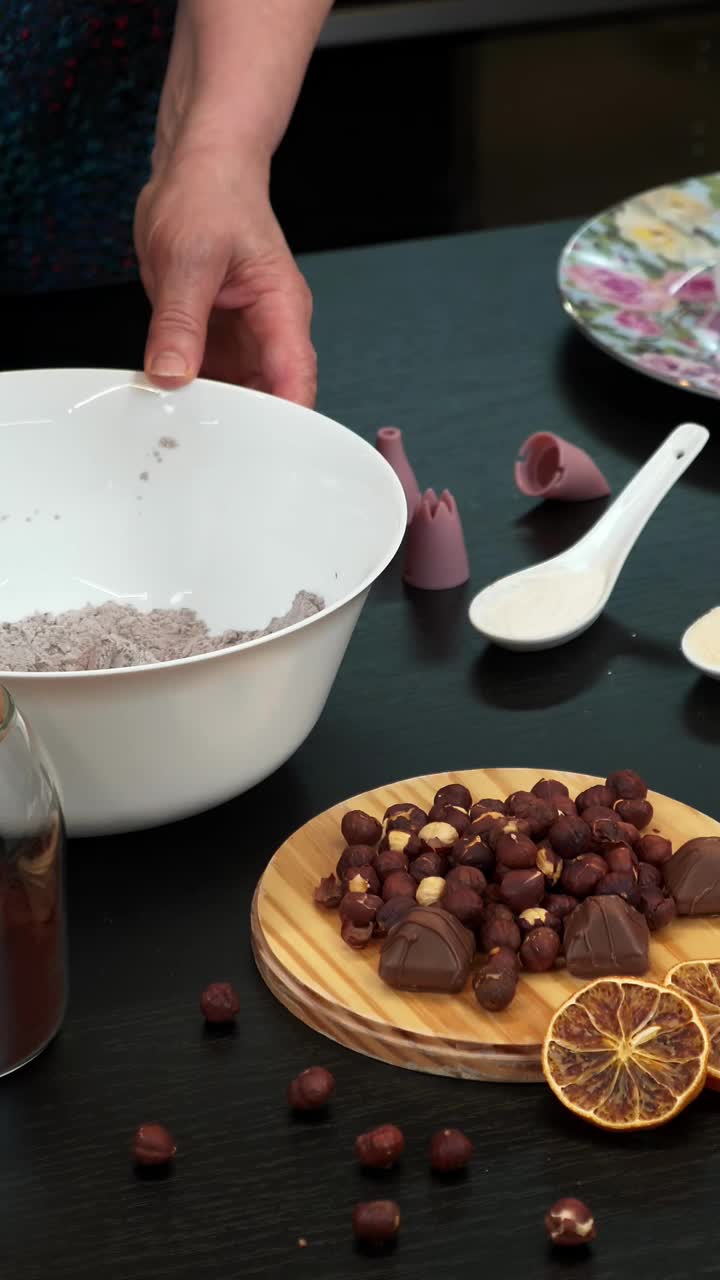 一个女人在家里用坚果烤巧克力蛋糕。垂直视频。在家做饭视频素材