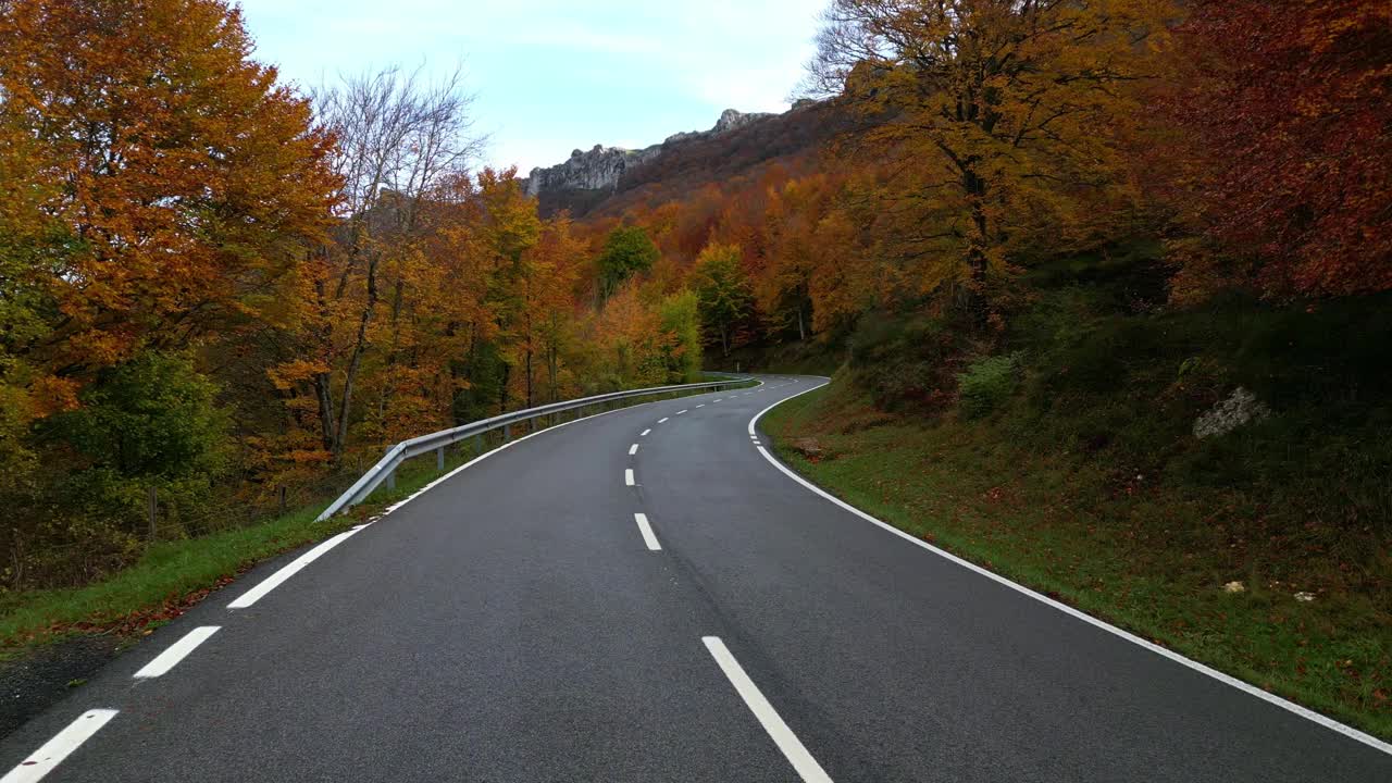 航拍视频的道路，以落基山脉周围的树木在秋天的森林视频素材