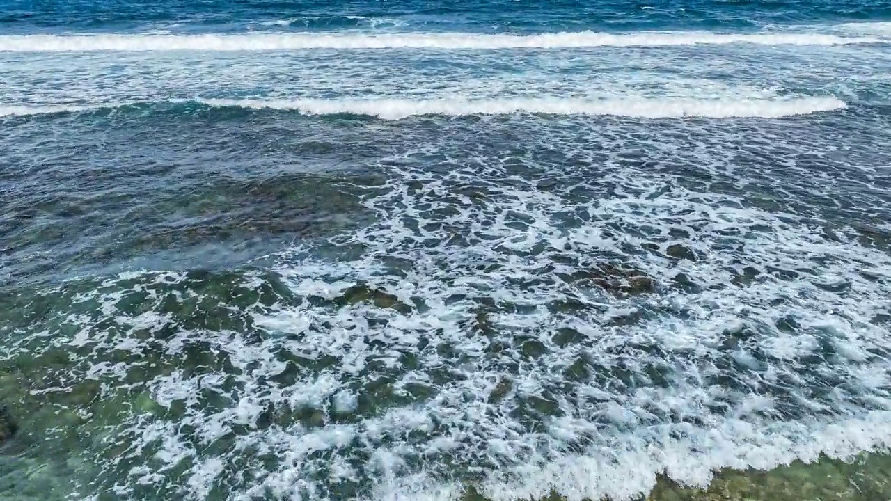 在遥远的夏威夷海滩上飞过蓝色的海浪视频素材