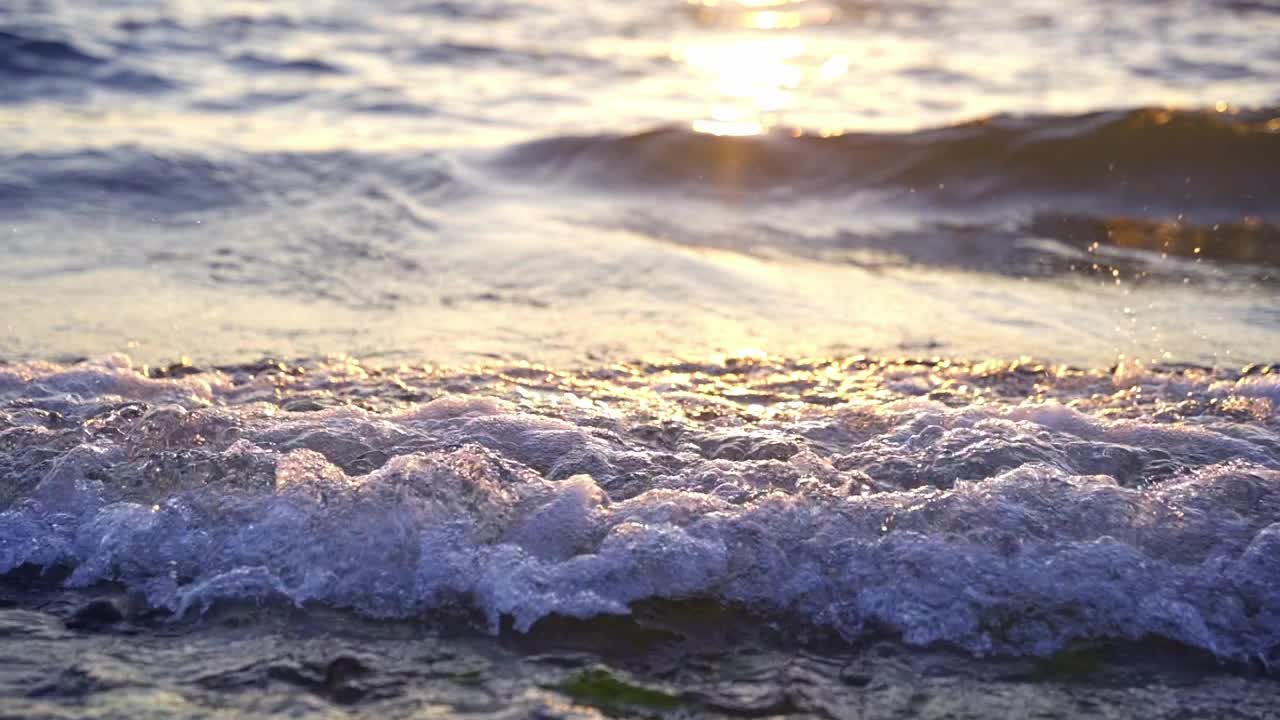 日落时海岸上的海浪和阳光的特写视频素材