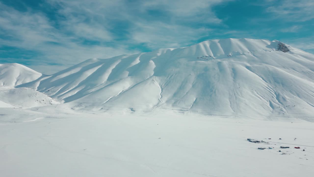 航拍视频显示，这条道路被冰雪覆盖的高大岩石山脉包围视频素材