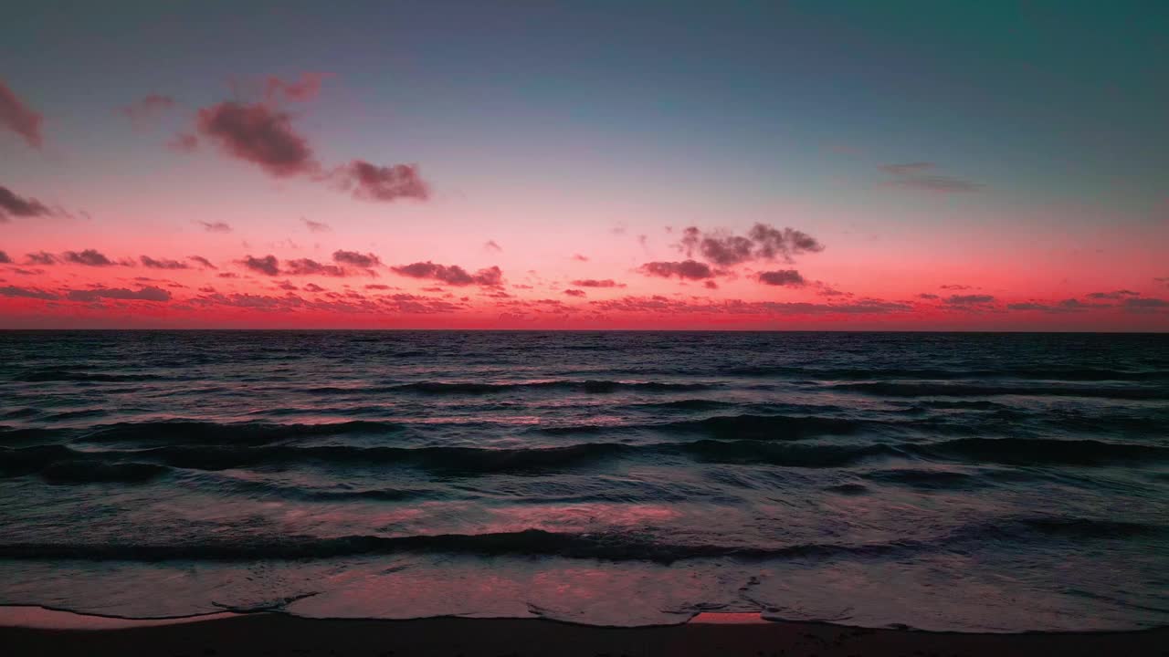 美丽的海潮波浪与红色的晚霞多云的天空在地平线上视频素材