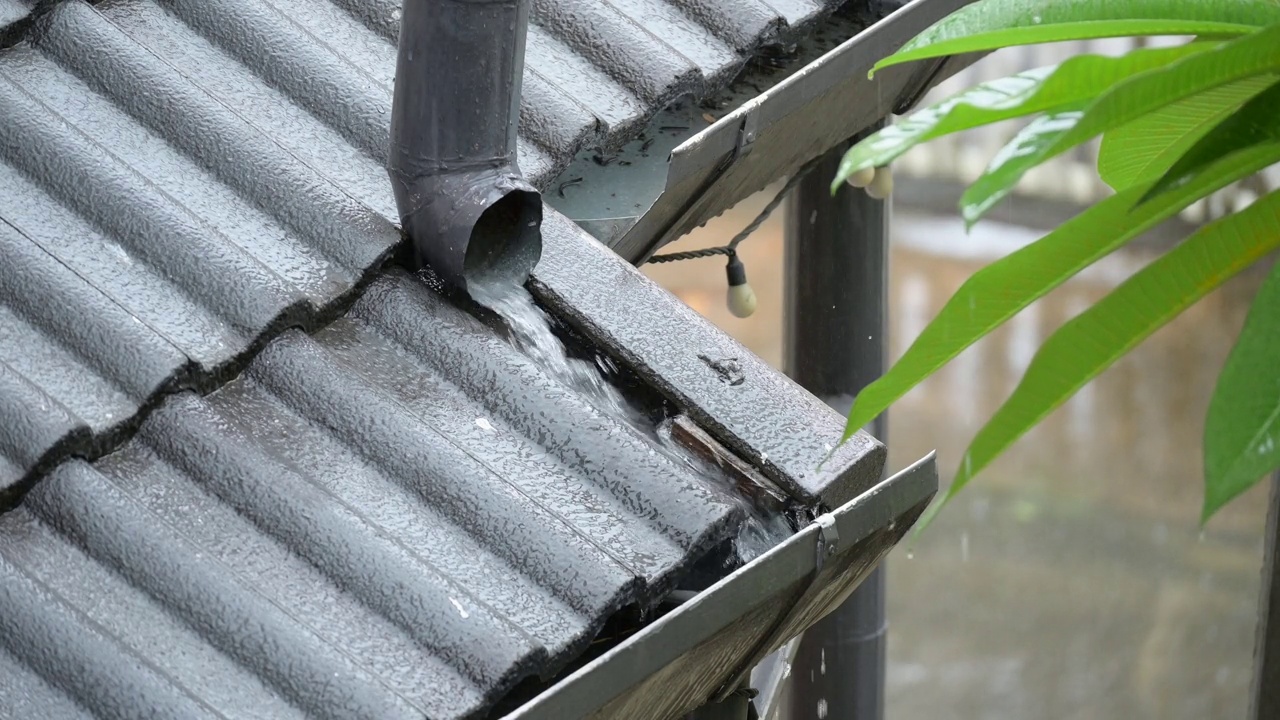 4K雨季场景，大雨倾泻在排水沟屋顶上的房子视频素材