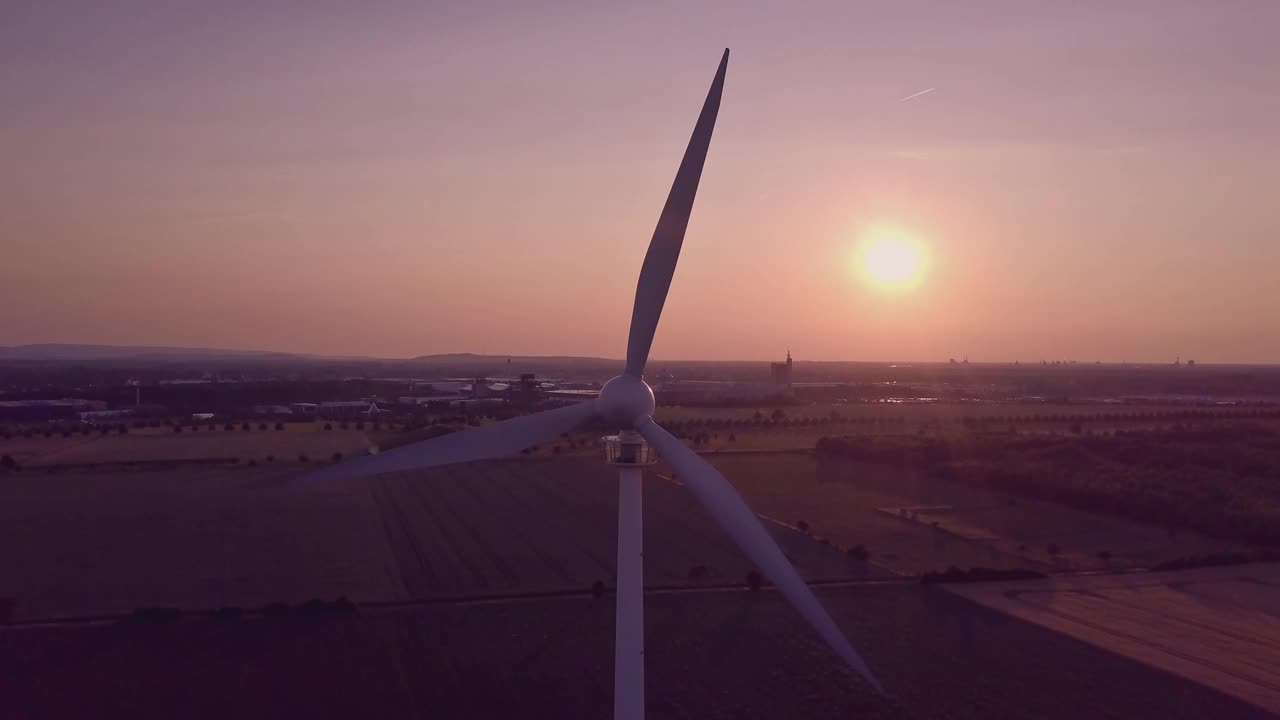 夕阳下橘黄色的夕阳映照下，风力发电机的景观景象，能量源源不断视频素材