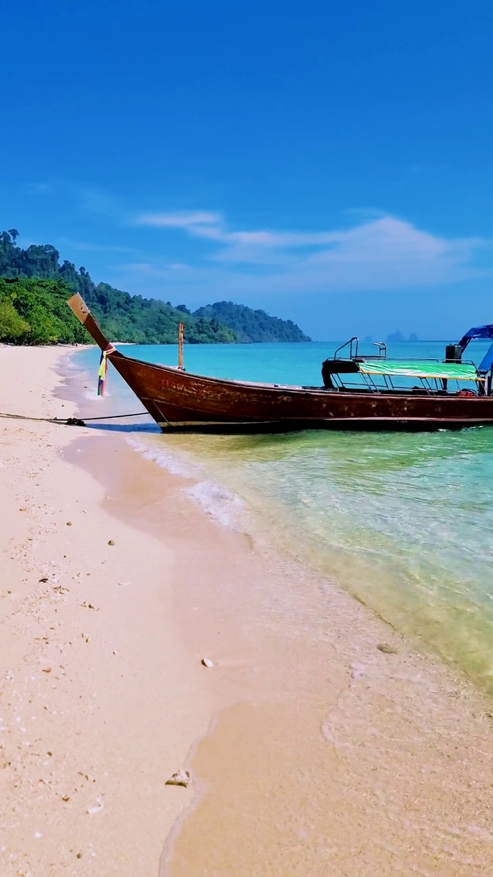 泰国南部的Koh Kradan岛，海滩上有长尾船和蓝绿色的海洋视频素材