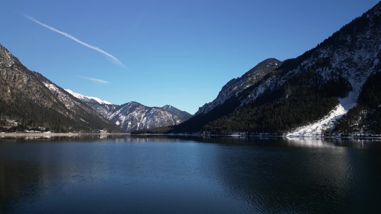 湖的航拍视频，岩石雪山覆盖着岸边的树木视频素材