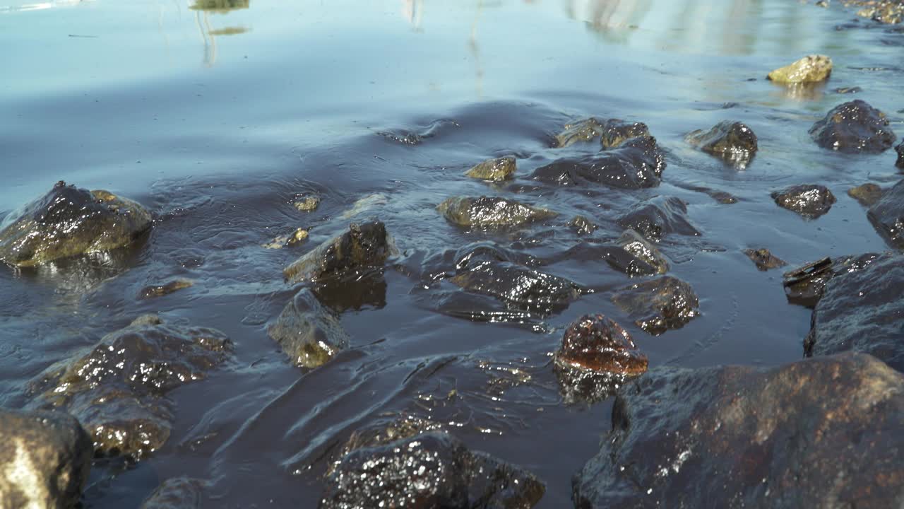 海边的特写，平静的海浪拍打着海滩上的石头视频素材