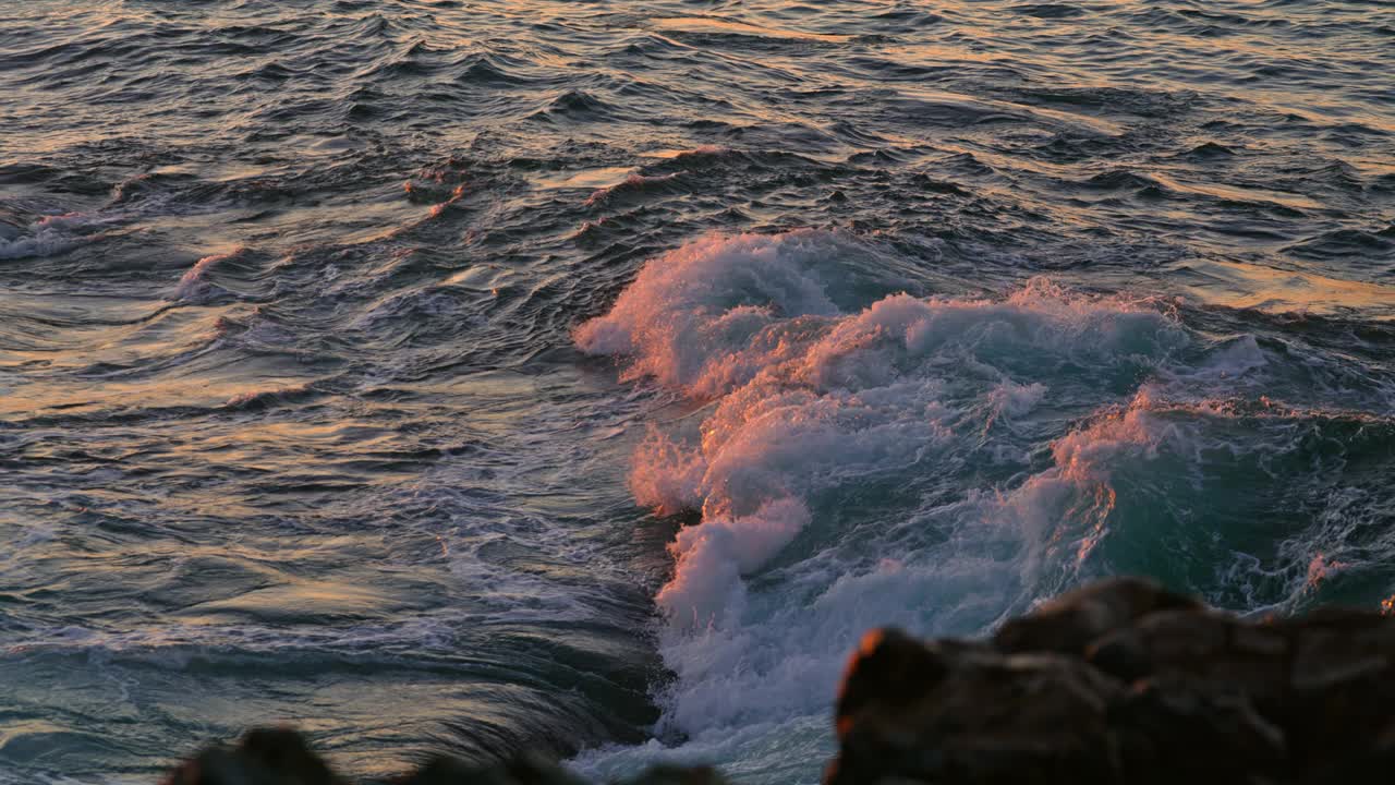 强大的海浪泡沫在日出大自然近距离。海浪飞溅视频素材