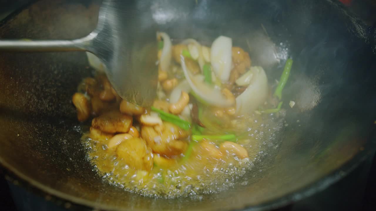 近距离烹饪泰国菜腰果炒鸡在厨房餐厅的煎锅视频素材