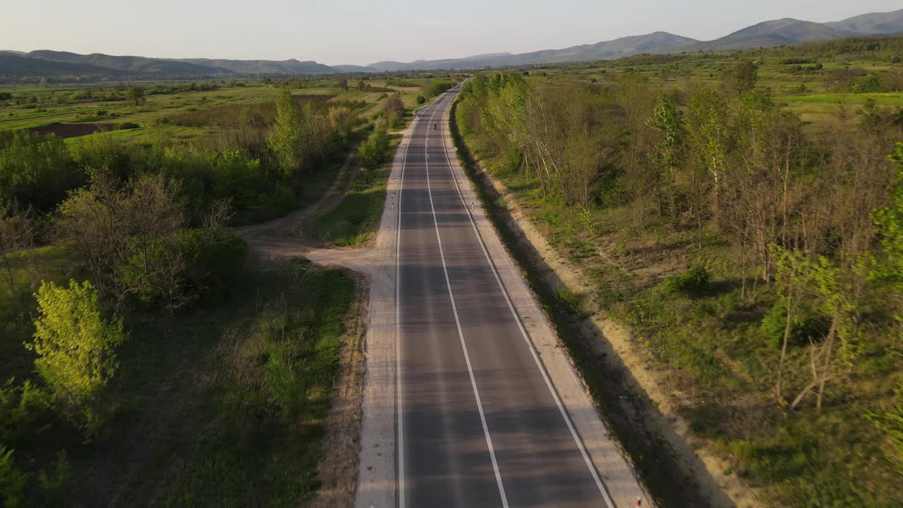 在春天晴朗的日子里，在开阔的道路上骑摩托车和开车视频素材