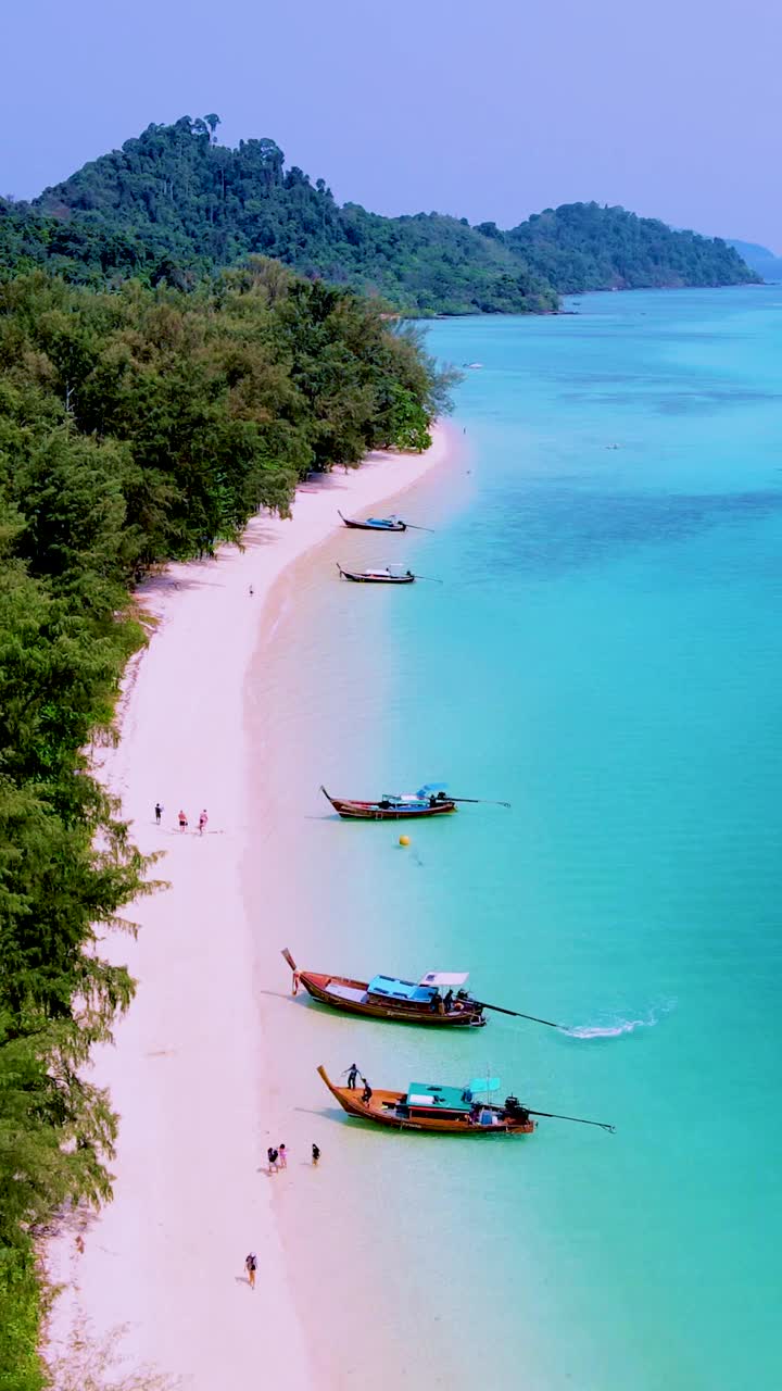 泰国南部的Koh Kradan岛，海滩上有长尾船和蓝绿色的海洋视频素材