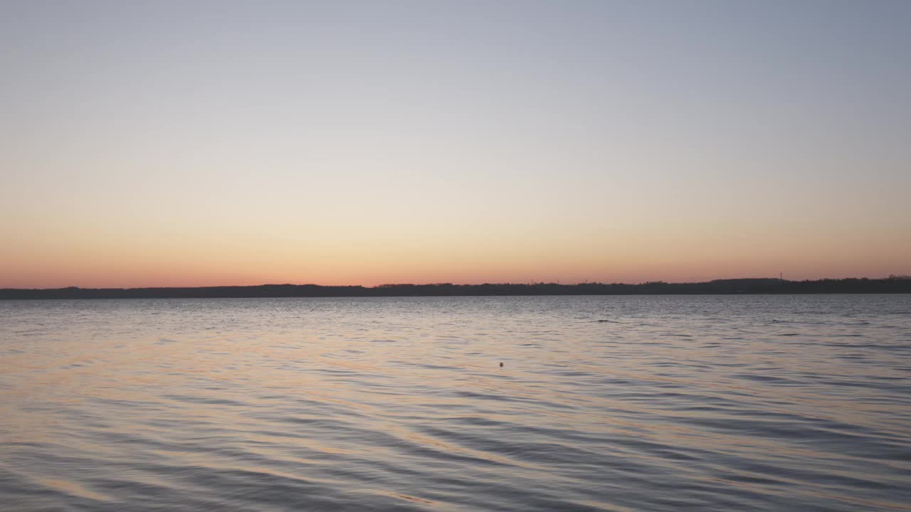 温柔的海浪和田园诗般的日落在海边视频素材