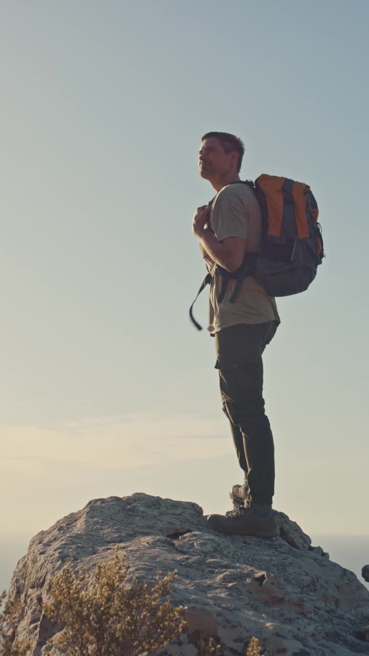 徒步旅行，自由和男人站在山顶上看海冒险。户外，徒步者和男性在山顶徒步旅行，锻炼或徒步旅行，日落和思考模型。视频素材