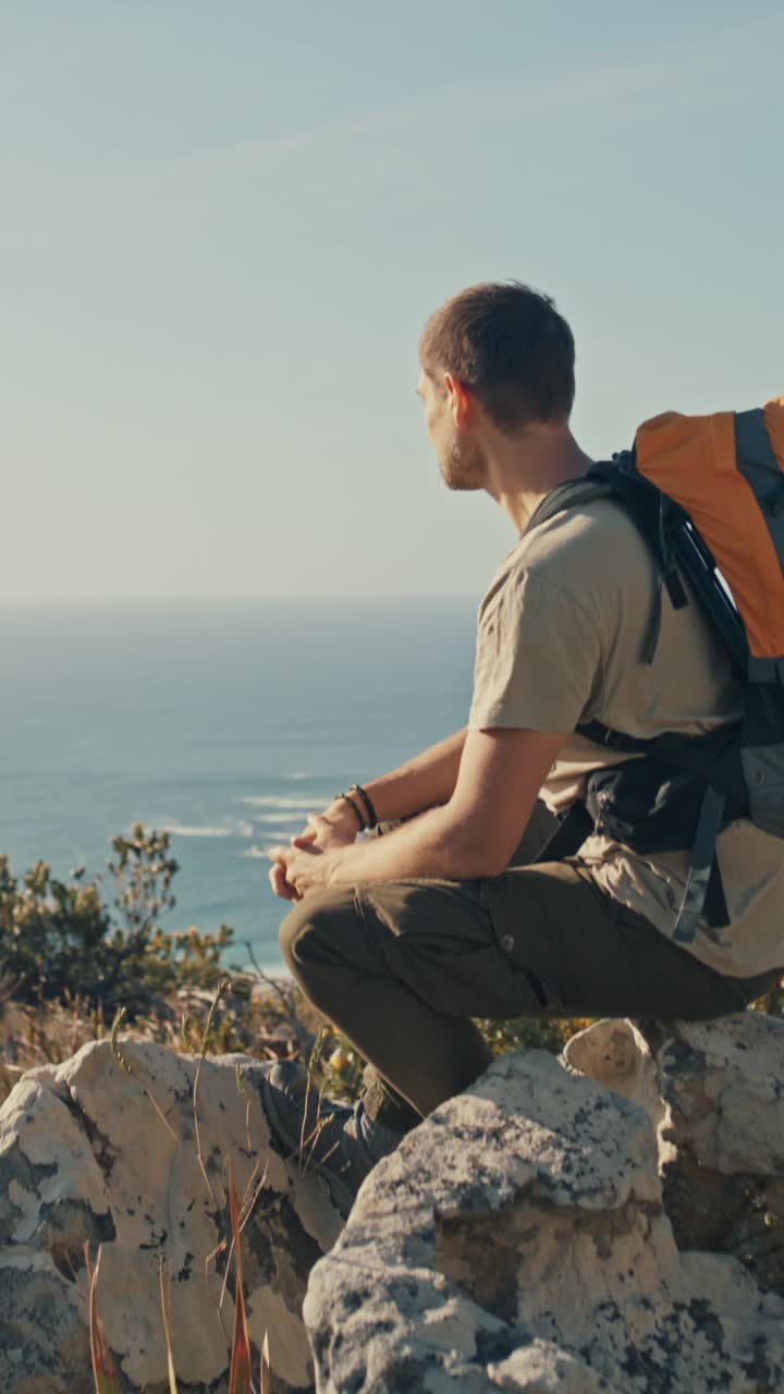 徒步旅行，思考和男人放松在山与海洋景观的冒险。户外，徒步旅行者和男性在徒步旅行，锻炼或徒步旅行后休息时坐在岩石上旅行，旅行和自由视频素材