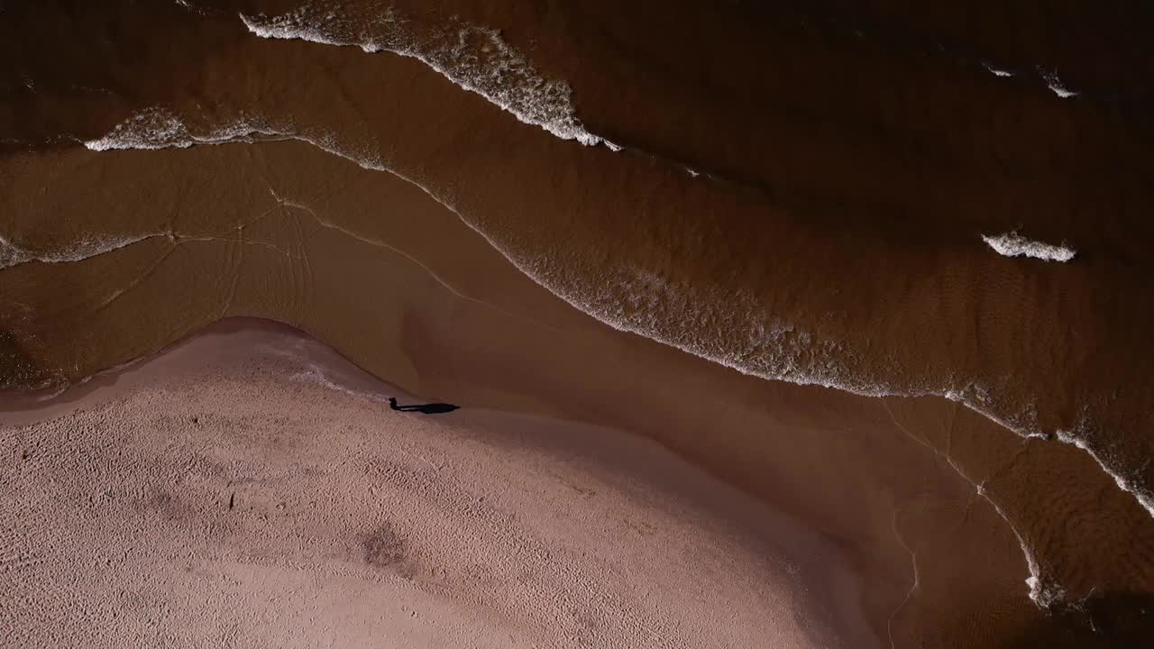 海浪、海洋、海岸的无人机鸟瞰图。海滩和沙丘黑暗平静的海浪自然景观拍摄无人机。旅游视频素材