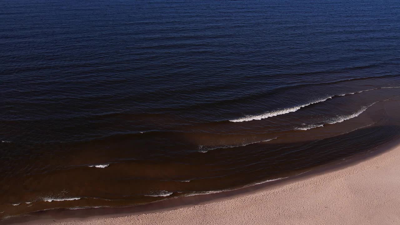 海浪、海洋、海岸的无人机鸟瞰图。海滩和沙丘黑暗平静的海浪自然景观拍摄无人机。旅游视频素材