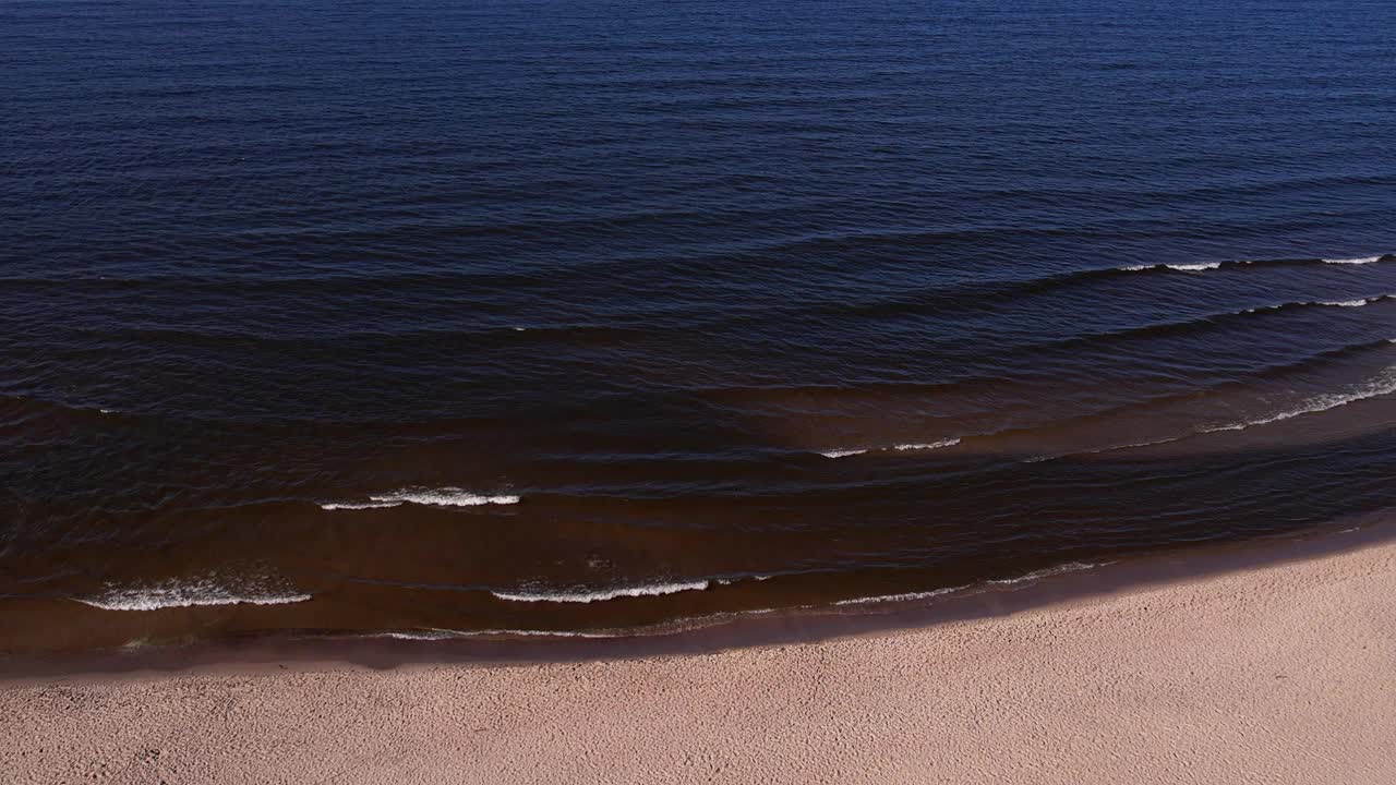 海浪、海洋、海岸的无人机鸟瞰图。海滩和沙丘黑暗平静的海浪自然景观拍摄无人机。旅游视频素材