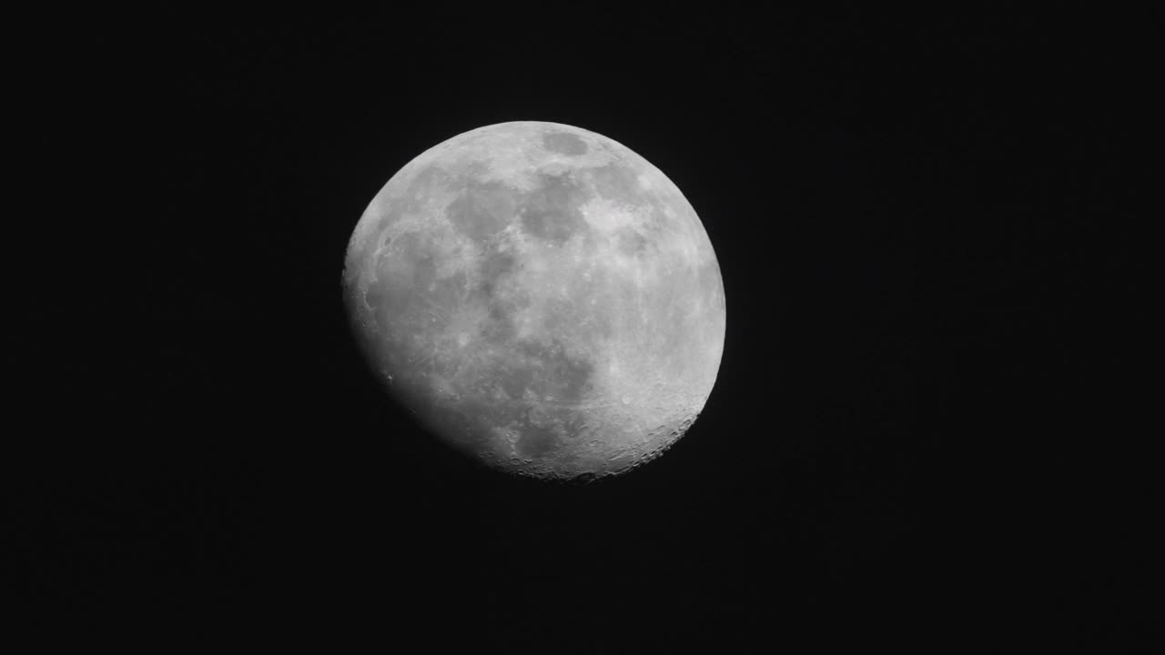 大飞机飞过明亮的月亮，夜晚满月的特写，黑色的天空背景，云层移动，月光闪耀，长焦镜头4k慢动作镜头。视频素材