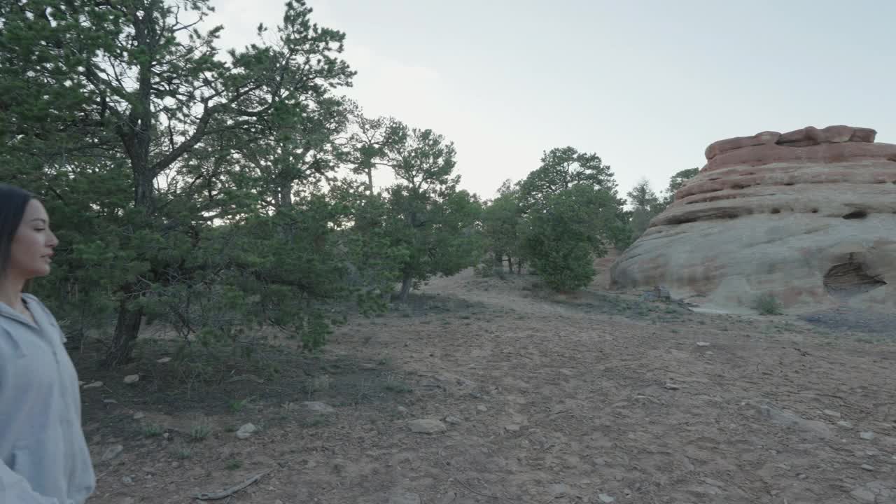 在科罗拉多州西部Fruita和Grand Junction上方的荒野山丘上，一对年轻的混血夫妇在春天的黄昏徒步旅行，这是一个慢镜头。视频素材