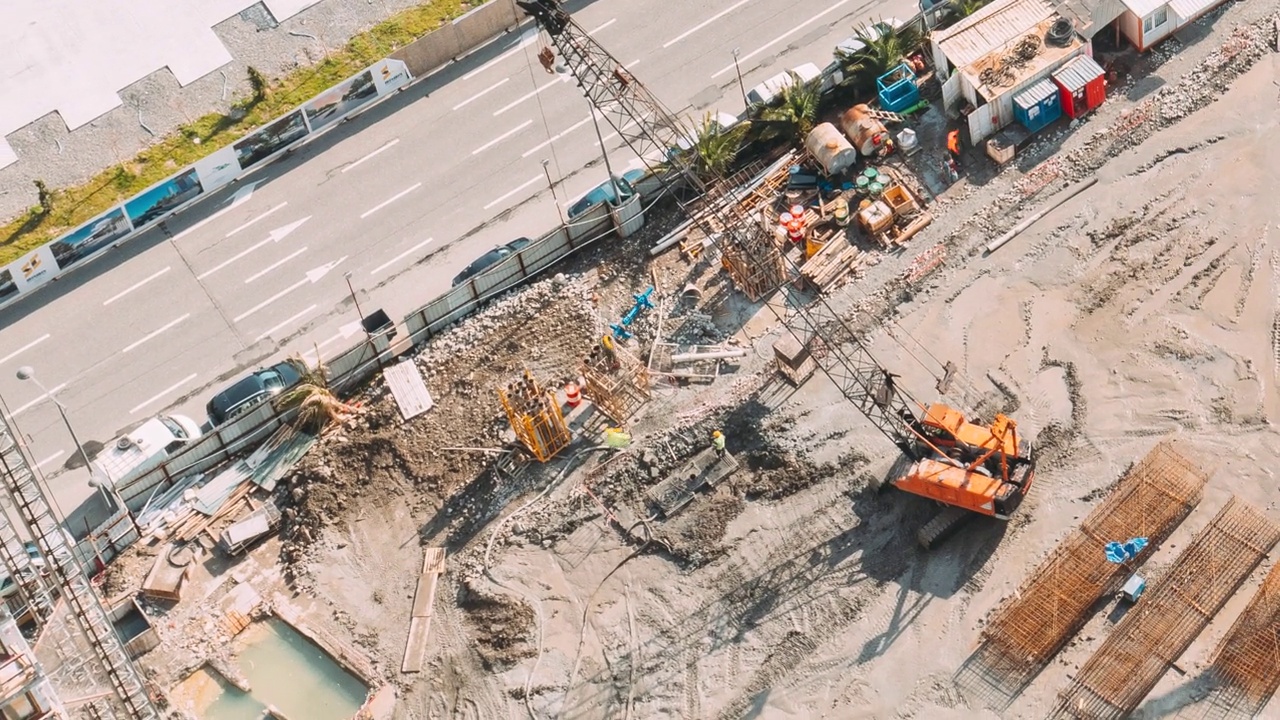 开发多层住宅楼。建筑工地的高清超缩鸟瞰图。施工现场金属结构建筑骨架的加工。各种机械起重机及工人从事维修开发视频素材