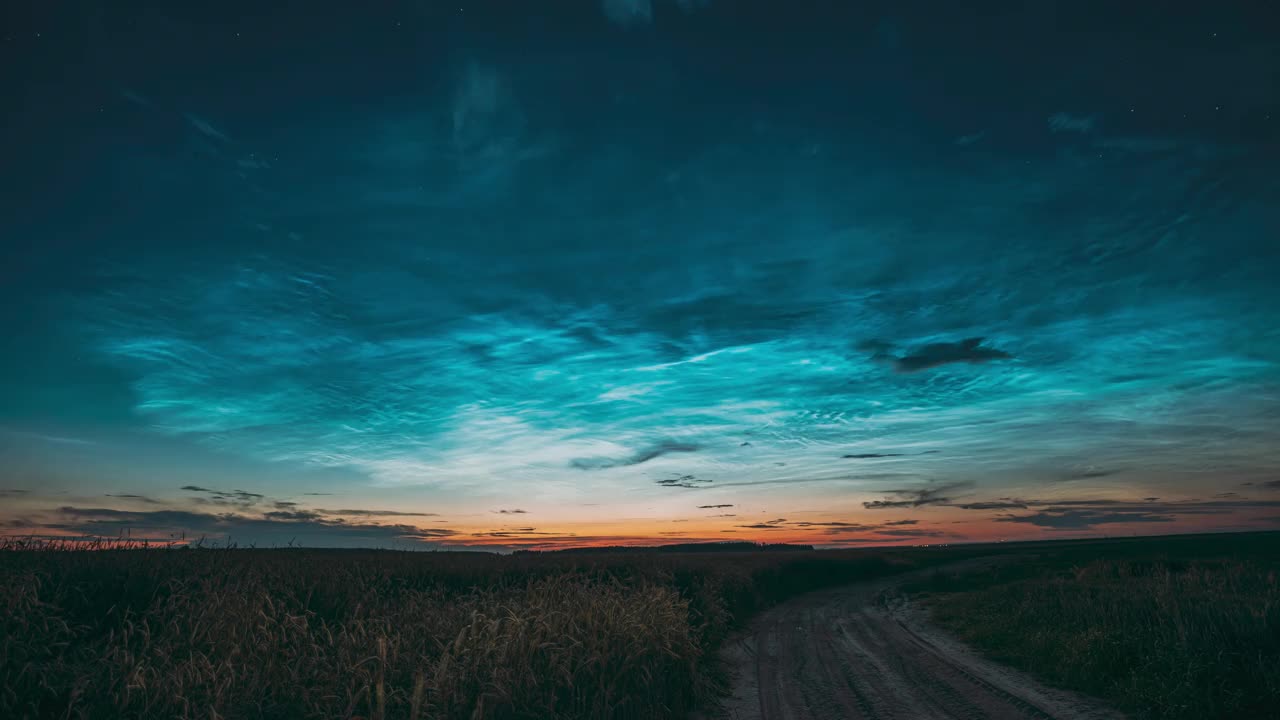 清晨的日出在乡村。自然背景。神奇的云和星星的效果，4k延时拍摄的不寻常的云和星星的效果在农村的田野景观与年轻的绿色小麦芽在春天，春天和夏天的一天视频素材