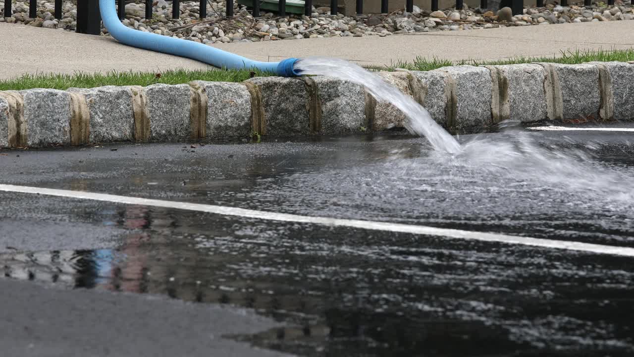 排水软管将水抽入停车场视频素材