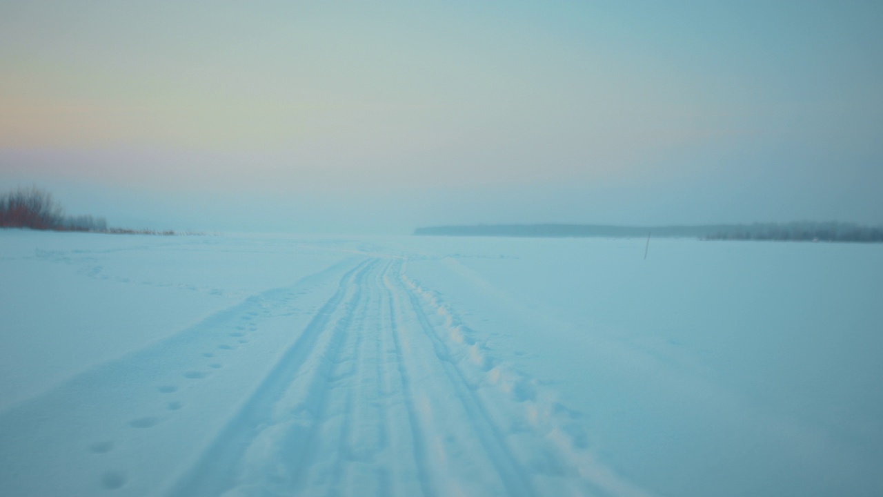 冬季在冰冻的河流上的雪地轨道，平静的雪景的近距离地面视图，4K, Prores视频素材