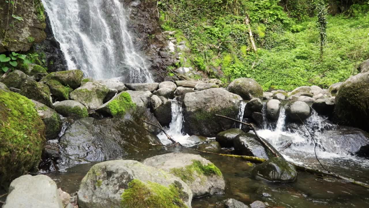 偏远的瀑布有一种荒野的感觉，没有文明的迹象，水流从上面的岩石上落在石头上视频素材