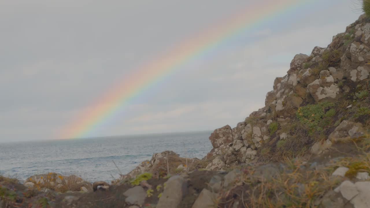 彩虹在岩石海岸进入海洋视频素材