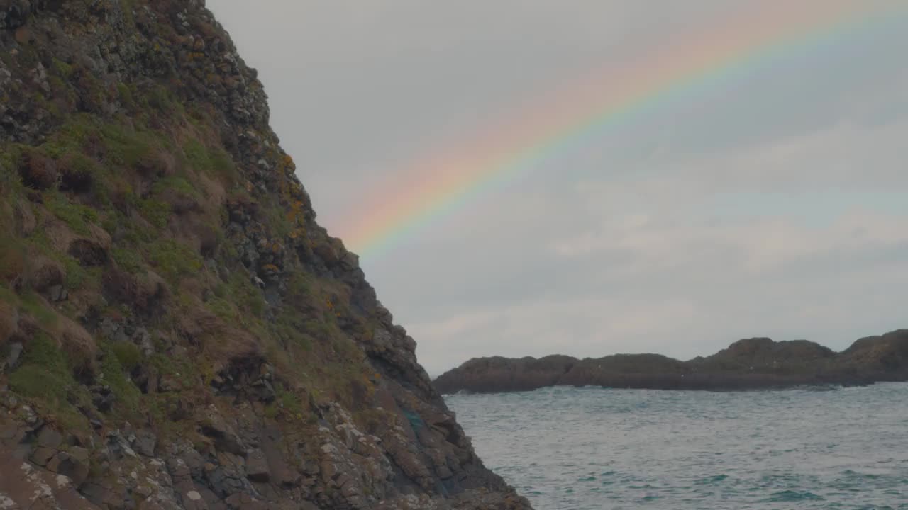 彩虹在岩石海岸进入海洋视频下载