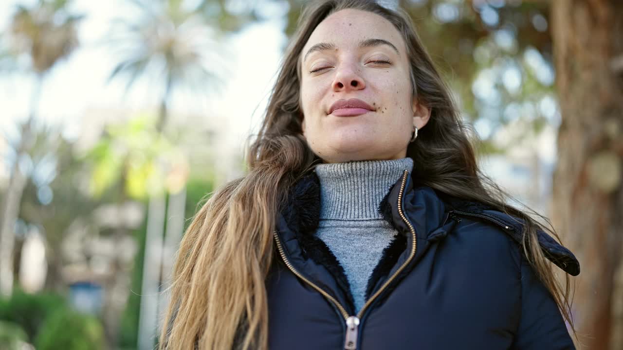 年轻的白人女子微笑着，自信地在公园里呼吸视频素材