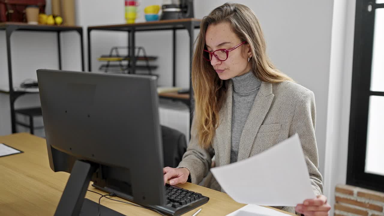 年轻的白人女性商务工作者在办公室用电脑阅读文件视频素材