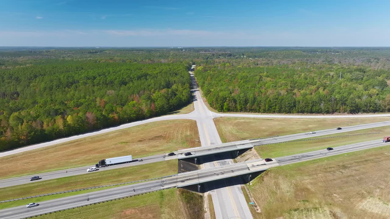 高速公路出口交叉路口的高架视图，车道上有快速移动的车辆和卡车。美国州际交通基础设施视频素材