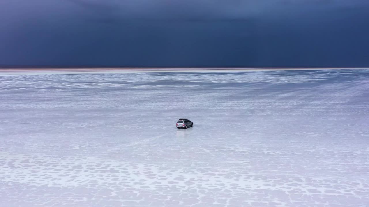 一辆四驱车载着游客在 Salar de Uyuni 停下来惊叹即将到来的暴风雨。视频素材