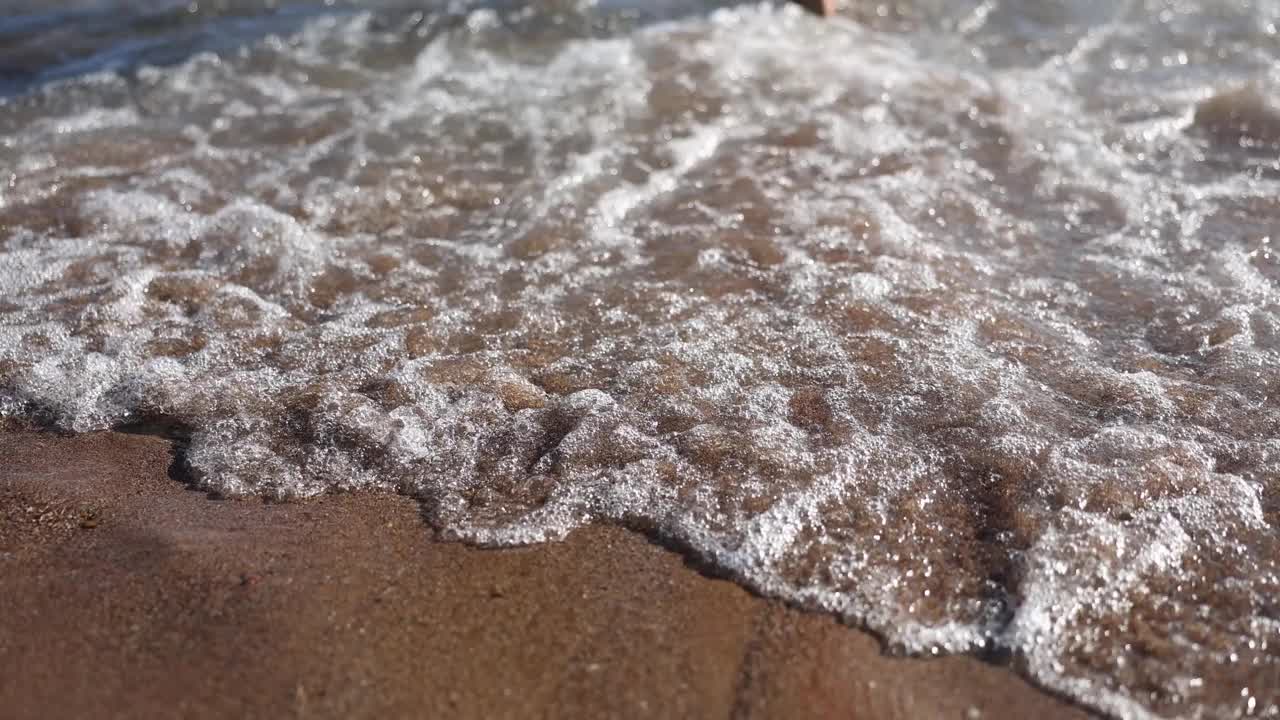 快乐的男人和女人在海浪冲刷的海滩上跳得很高视频素材