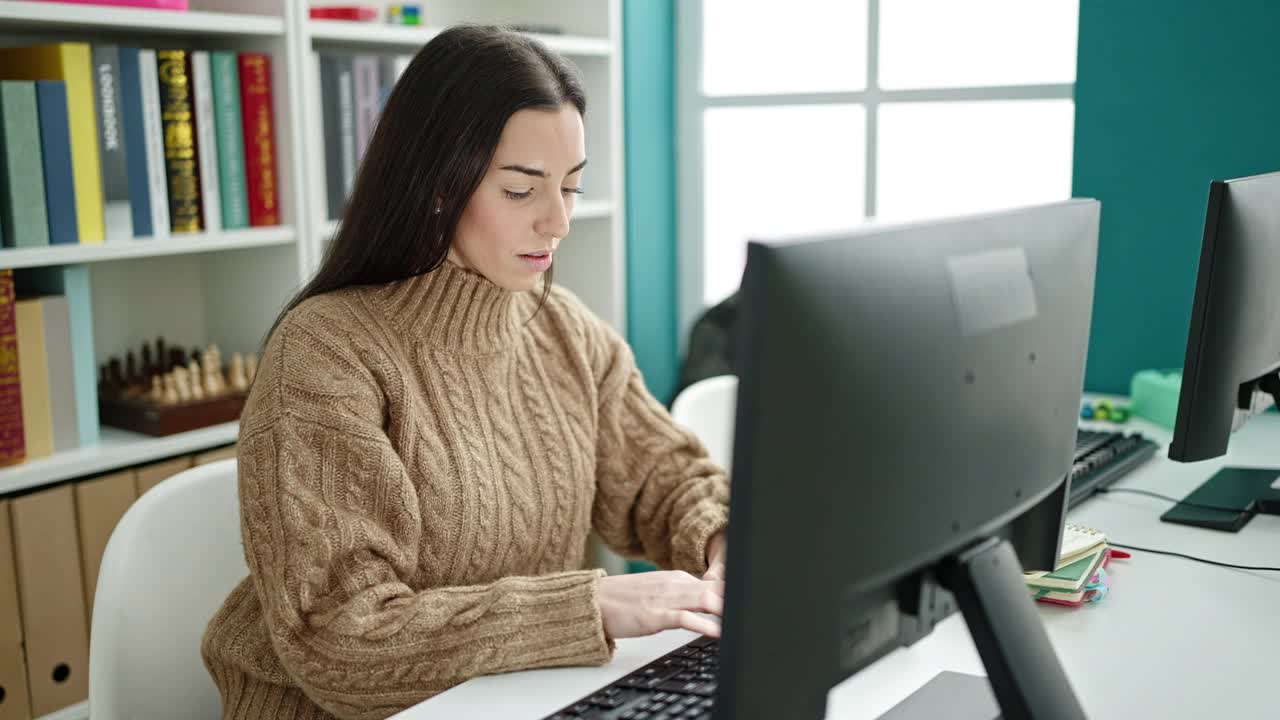 年轻漂亮的西班牙女学生在大学教室里用胜利者的表情使用电脑视频素材